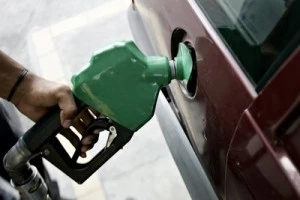 A pump attendant fills up a car with gas